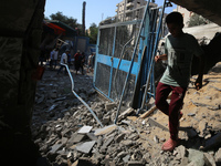 People are checking the destruction at a UN-run school after Israeli bombardment in Nuseirat, in the central Gaza Strip, on July 14, 2024, a...