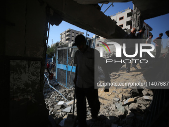 People are checking the destruction at a UN-run school after Israeli bombardment in Nuseirat, in the central Gaza Strip, on July 14, 2024, a...