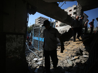 People are checking the destruction at a UN-run school after Israeli bombardment in Nuseirat, in the central Gaza Strip, on July 14, 2024, a...