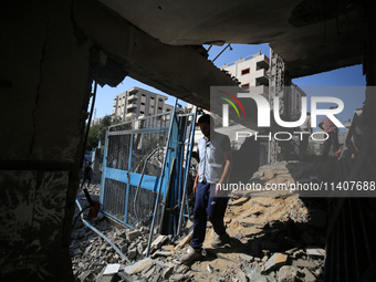 People are checking the destruction at a UN-run school after Israeli bombardment in Nuseirat, in the central Gaza Strip, on July 14, 2024, a...