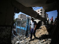 People are checking the destruction at a UN-run school after Israeli bombardment in Nuseirat, in the central Gaza Strip, on July 14, 2024, a...