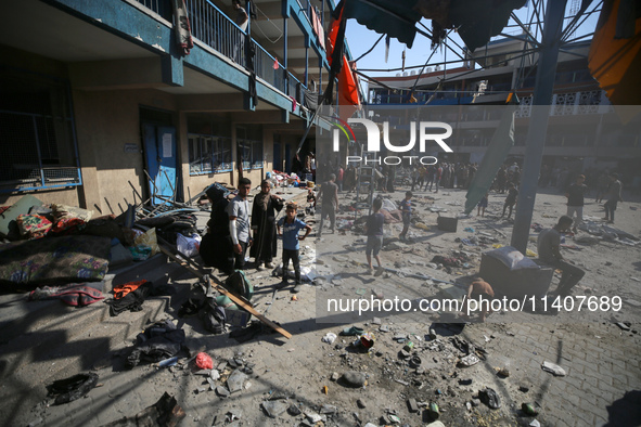 People are checking the destruction at a UN-run school after Israeli bombardment in Nuseirat, in the central Gaza Strip, on July 14, 2024, a...