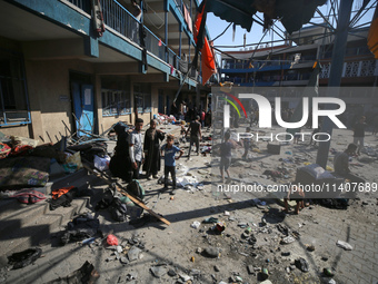 People are checking the destruction at a UN-run school after Israeli bombardment in Nuseirat, in the central Gaza Strip, on July 14, 2024, a...