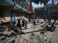 People are checking the destruction at a UN-run school after Israeli bombardment in Nuseirat, in the central Gaza Strip, on July 14, 2024, a...