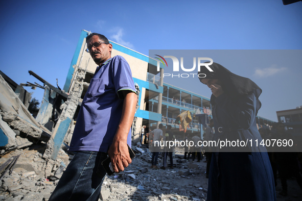 People are checking the destruction at a UN-run school after Israeli bombardment in Nuseirat, in the central Gaza Strip, on July 14, 2024, a...