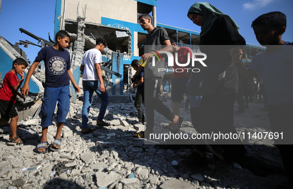 People are checking the destruction at a UN-run school after Israeli bombardment in Nuseirat, in the central Gaza Strip, on July 14, 2024, a...