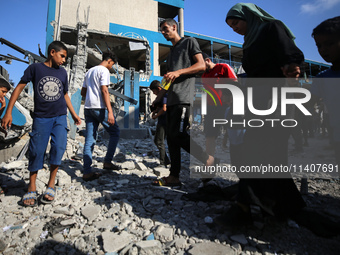 People are checking the destruction at a UN-run school after Israeli bombardment in Nuseirat, in the central Gaza Strip, on July 14, 2024, a...