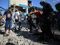 People are checking the destruction at a UN-run school after Israeli bombardment in Nuseirat, in the central Gaza Strip, on July 14, 2024, a...