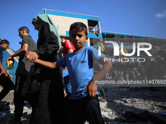 People are checking the destruction at a UN-run school after Israeli bombardment in Nuseirat, in the central Gaza Strip, on July 14, 2024, a...