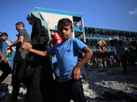 People are checking the destruction at a UN-run school after Israeli bombardment in Nuseirat, in the central Gaza Strip, on July 14, 2024, a...