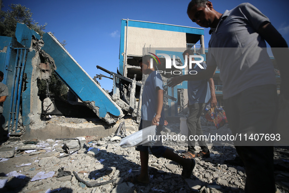 People are checking the destruction at a UN-run school after Israeli bombardment in Nuseirat, in the central Gaza Strip, on July 14, 2024, a...