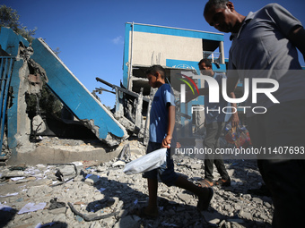 People are checking the destruction at a UN-run school after Israeli bombardment in Nuseirat, in the central Gaza Strip, on July 14, 2024, a...