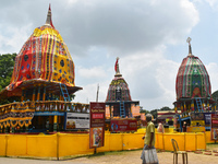 A person is passing next to chariots of Hindu lord Jagannath, Balaram, and Subhadra ahead of the Ulta Rath festival in Kolkata, India, on Ju...