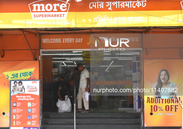 A security person is checking a customer inside a supermarket in Kolkata, India, on July 14, 2024. 