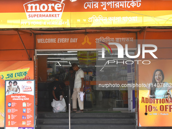 A security person is checking a customer inside a supermarket in Kolkata, India, on July 14, 2024. (