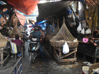 People are riding on a scooter inside a market in Kolkata, India, on July 14, 2024. (