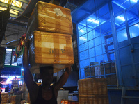 A person is carrying products on his head inside a market in Kolkata, India, on July 14, 2024. (