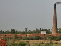 Smoke is rising from a brick factory in Najibabad, Uttar Pradesh, India, on April 19, 2024. (