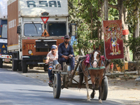 People are traveling by horse cart along a road in Najibabad, Uttar Pradesh, India, on April 19, 2024. (