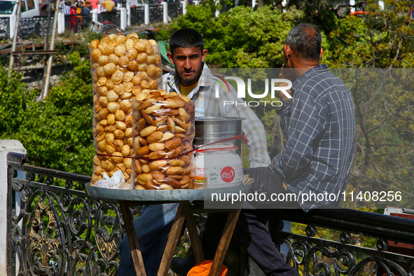 Men are selling snacks along Mall Road in Mussoorie, Uttarakhand, India, on April 18, 2024. 