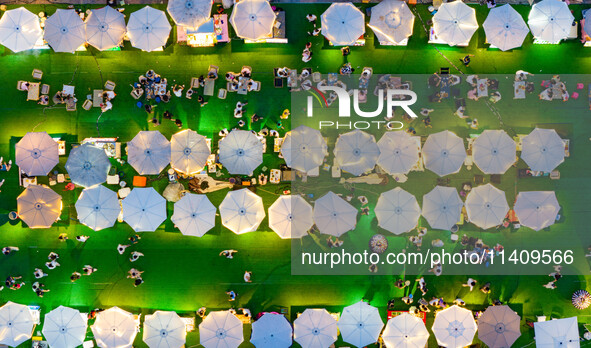 People are eating food at the night market on Nanbin Road in Chongqing, China, on July 14, 2024. It is reported that with the arrival of the...