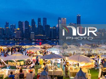 People are eating food at the night market on Nanbin Road in Chongqing, China, on July 14, 2024. It is reported that with the arrival of the...