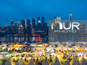 People are eating food at the night market on Nanbin Road in Chongqing, China, on July 14, 2024. It is reported that with the arrival of the...