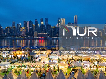 People are eating food at the night market on Nanbin Road in Chongqing, China, on July 14, 2024. It is reported that with the arrival of the...