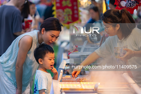 People are eating food at the night market on Nanbin Road in Chongqing, China, on July 14, 2024. It is reported that with the arrival of the...