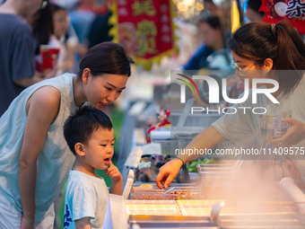 People are eating food at the night market on Nanbin Road in Chongqing, China, on July 14, 2024. It is reported that with the arrival of the...