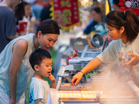 People are eating food at the night market on Nanbin Road in Chongqing, China, on July 14, 2024. It is reported that with the arrival of the...