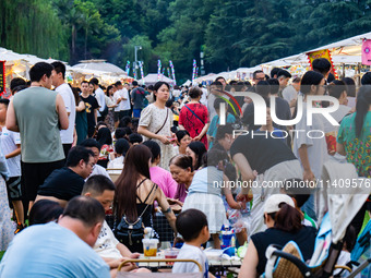 People are eating food at the night market on Nanbin Road in Chongqing, China, on July 14, 2024. It is reported that with the arrival of the...