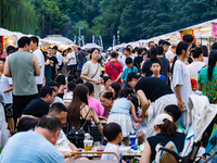 People are eating food at the night market on Nanbin Road in Chongqing, China, on July 14, 2024. It is reported that with the arrival of the...