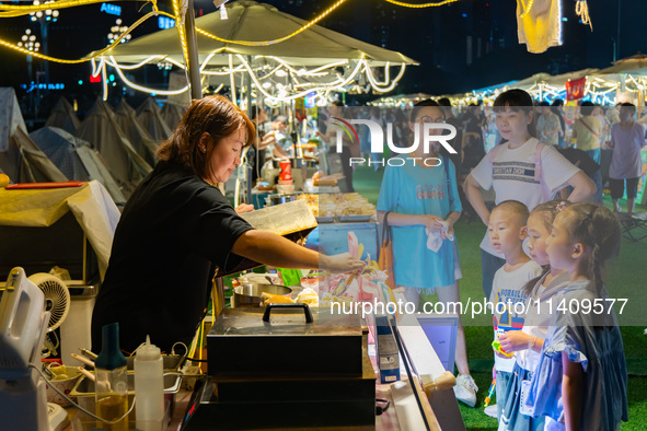 People are eating food at the night market on Nanbin Road in Chongqing, China, on July 14, 2024. It is reported that with the arrival of the...