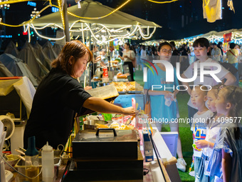 People are eating food at the night market on Nanbin Road in Chongqing, China, on July 14, 2024. It is reported that with the arrival of the...