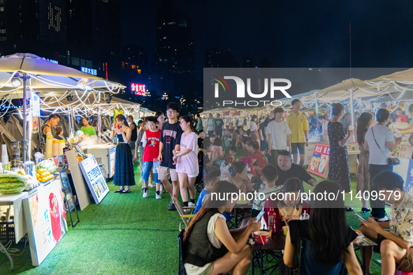 People are eating food at the night market on Nanbin Road in Chongqing, China, on July 14, 2024. It is reported that with the arrival of the...