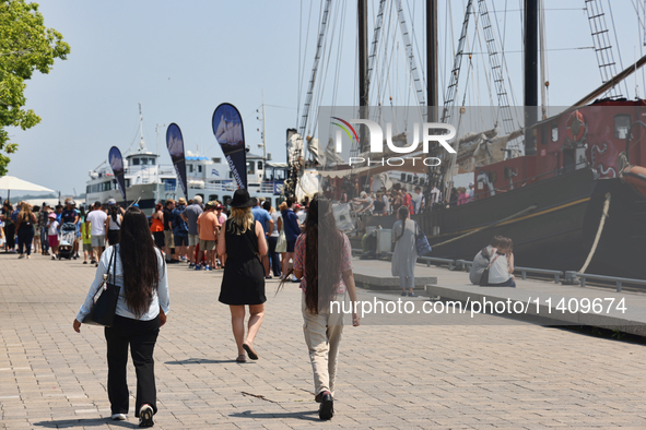 People are walking along the boardwalk at Harbourfront in Toronto, Ontario, Canada, on July 13, 2024. 