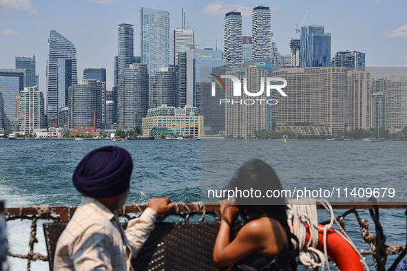 People are admiring the Toronto city skyline as they are traveling in a water taxi along Lake Ontario in Toronto, Ontario, Canada, on July 1...