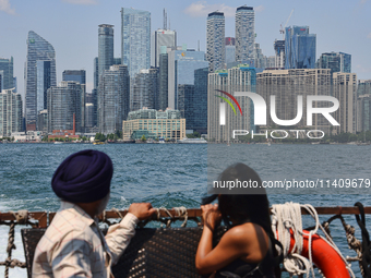 People are admiring the Toronto city skyline as they are traveling in a water taxi along Lake Ontario in Toronto, Ontario, Canada, on July 1...