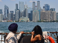 People are admiring the Toronto city skyline as they are traveling in a water taxi along Lake Ontario in Toronto, Ontario, Canada, on July 1...