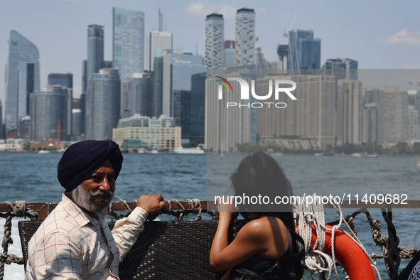 People are admiring the Toronto city skyline as they are traveling in a water taxi along Lake Ontario in Toronto, Ontario, Canada, on July 1...