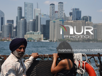 People are admiring the Toronto city skyline as they are traveling in a water taxi along Lake Ontario in Toronto, Ontario, Canada, on July 1...