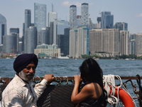 People are admiring the Toronto city skyline as they are traveling in a water taxi along Lake Ontario in Toronto, Ontario, Canada, on July 1...