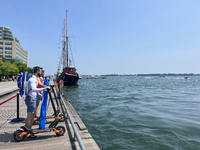 People are riding scooters along the boardwalk at Harbourfront in Toronto, Ontario, Canada, on July 13, 2024. (