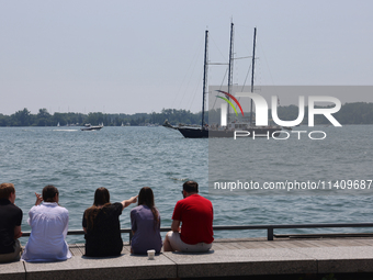 People are admiring boats along Harbourfront in Toronto, Ontario, Canada, on July 13, 2024. (