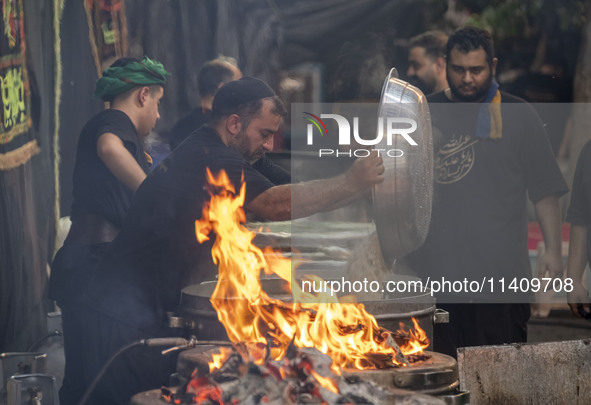 An Iraqi man living in Iran is preparing donated meals for worshippers during a religious rally to commemorate Tasoua, in Dolatabad neighbor...