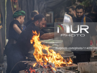 An Iraqi man living in Iran is preparing donated meals for worshippers during a religious rally to commemorate Tasoua, in Dolatabad neighbor...