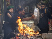 An Iraqi man living in Iran is preparing donated meals for worshippers during a religious rally to commemorate Tasoua, in Dolatabad neighbor...