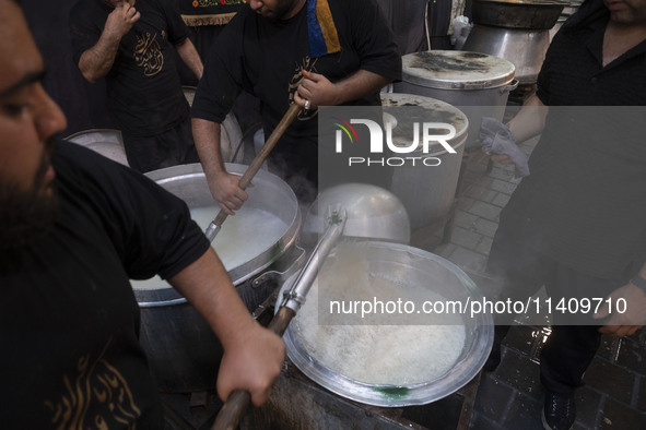 Iraqi men living in Iran are preparing donated meals for worshippers during a religious rally to commemorate Tasoua, in Dolatabad neighborho...