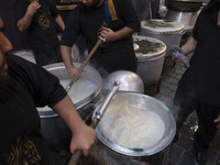 Iraqi men living in Iran are preparing donated meals for worshippers during a religious rally to commemorate Tasoua, in Dolatabad neighborho...